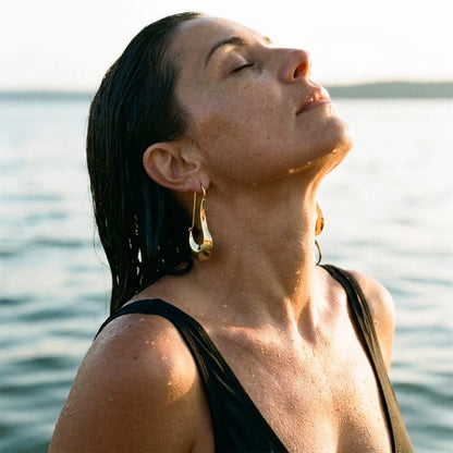 18K gold plated sculpted crescent drop earrings, worn in the water at golden hour | SKU: AUR-SCPCRS-G