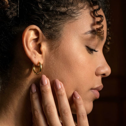 18K gold plated tiny huggie hoop earrings, worn, close detail in warm light | SKU: AUR-TNYHUG-G