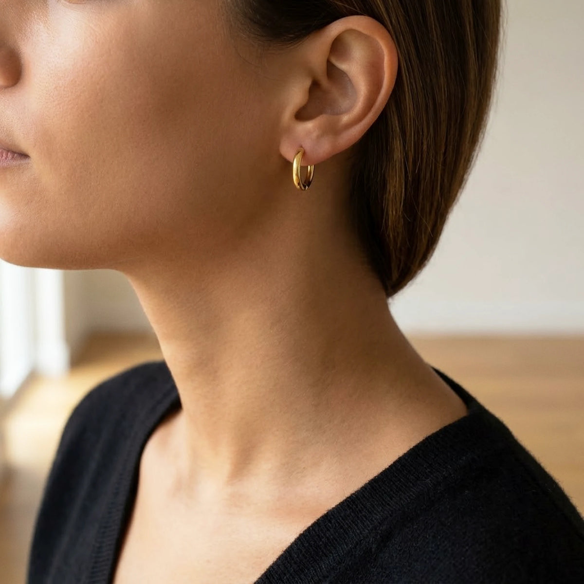 18K gold plated tiny huggie hoop earrings, worn, three quarter view | SKU: AUR-TNYHUG-G