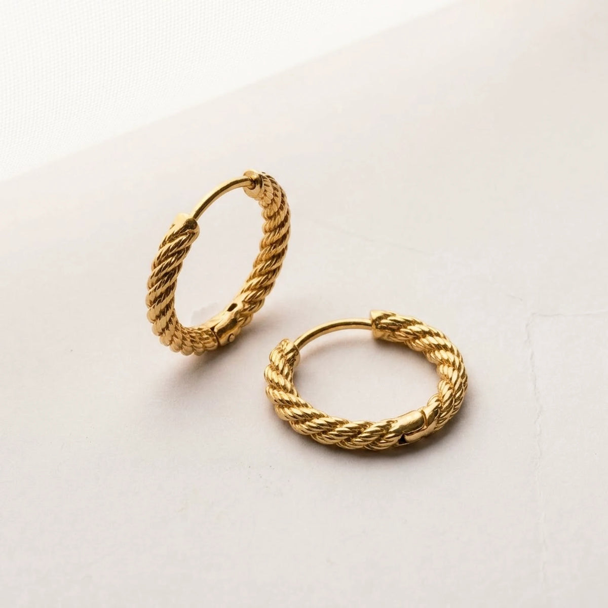 18K gold plated twisted rope huggie hoop earrings, product shot on white | SKU: AUR-TWRHUG-G