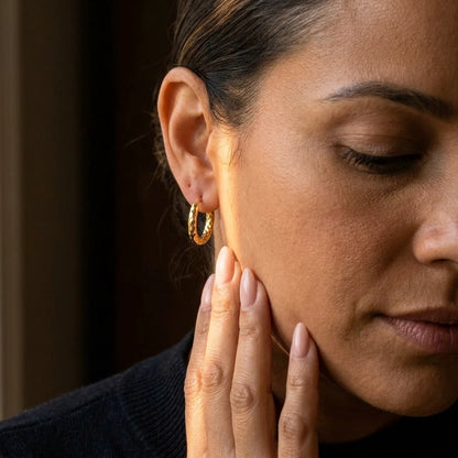 18K gold plated twisted rope huggie hoop earrings, worn, close detail in warm light | SKU: AUR-TWRHUG-G
