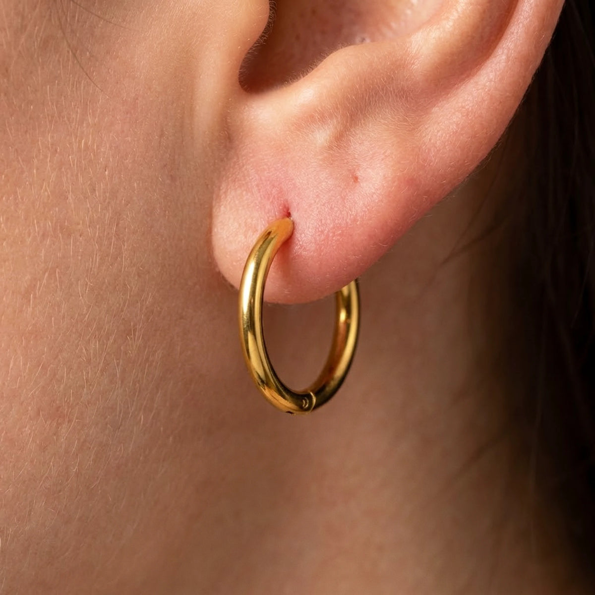 18K gold plated waterproof hoop earrings, macro detail on the earlobe | SKU: AUR-CLSHOP-G