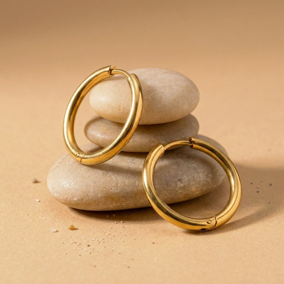 18K gold plated waterproof hoop earrings, still life on smooth stones | SKU: AUR-CLSHOP-G
