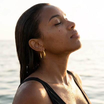 18K gold plated waterproof hoop earrings, worn in the water at golden hour | SKU: AUR-CLSHOP-G