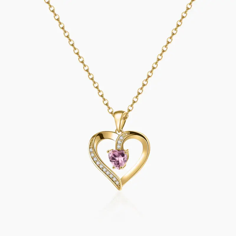 Aureate Heart Birthstone Necklace featuring a heart-shaped pendant with a pink gemstone and sparkling accents.