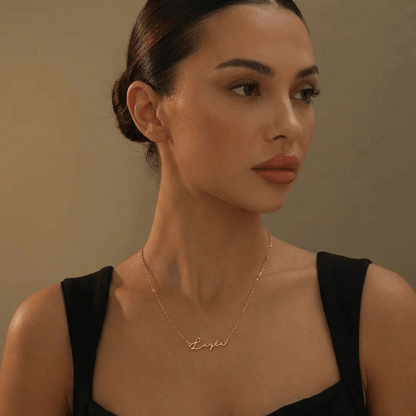 Elegant woman wearing AUREATE Petit Name Necklace in gold, showcasing a personalized design that enhances her beauty.
