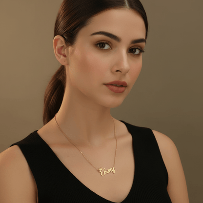 Woman wearing a gold Royal Style Name Necklace with the name 'Ebony' featured prominently, showcasing elegance.