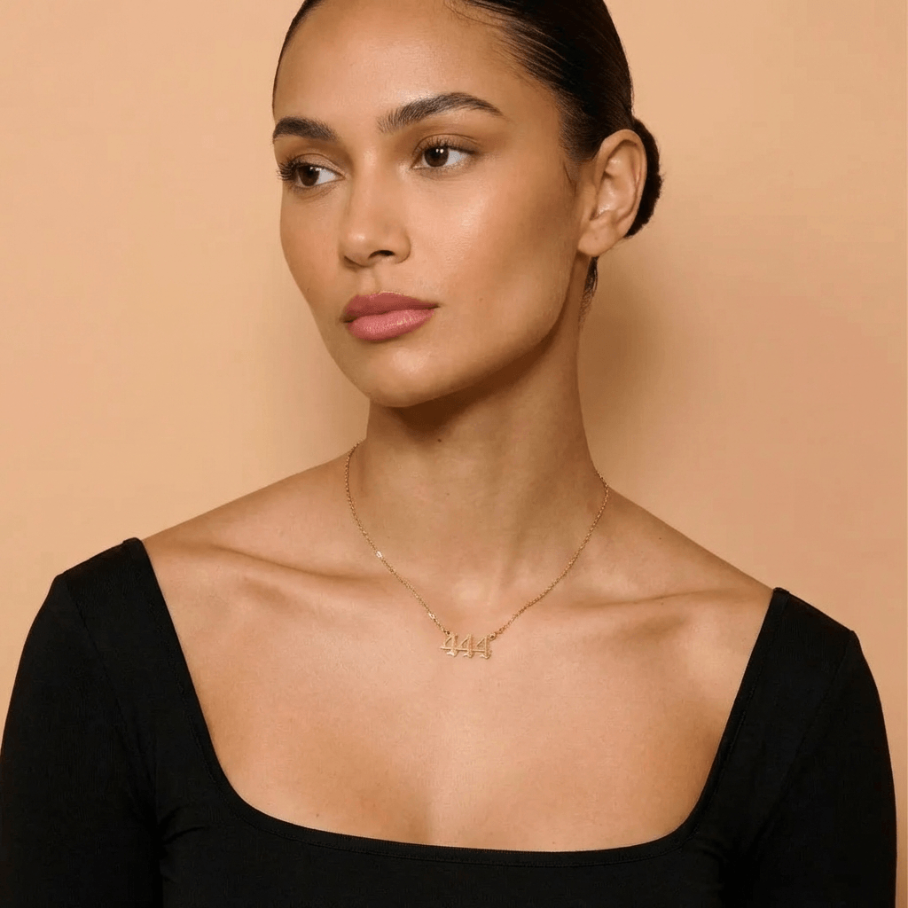 Angel Number Pendant Necklace by AUREATE worn by model on simple backdrop, showcasing stylish spiritual jewelry.