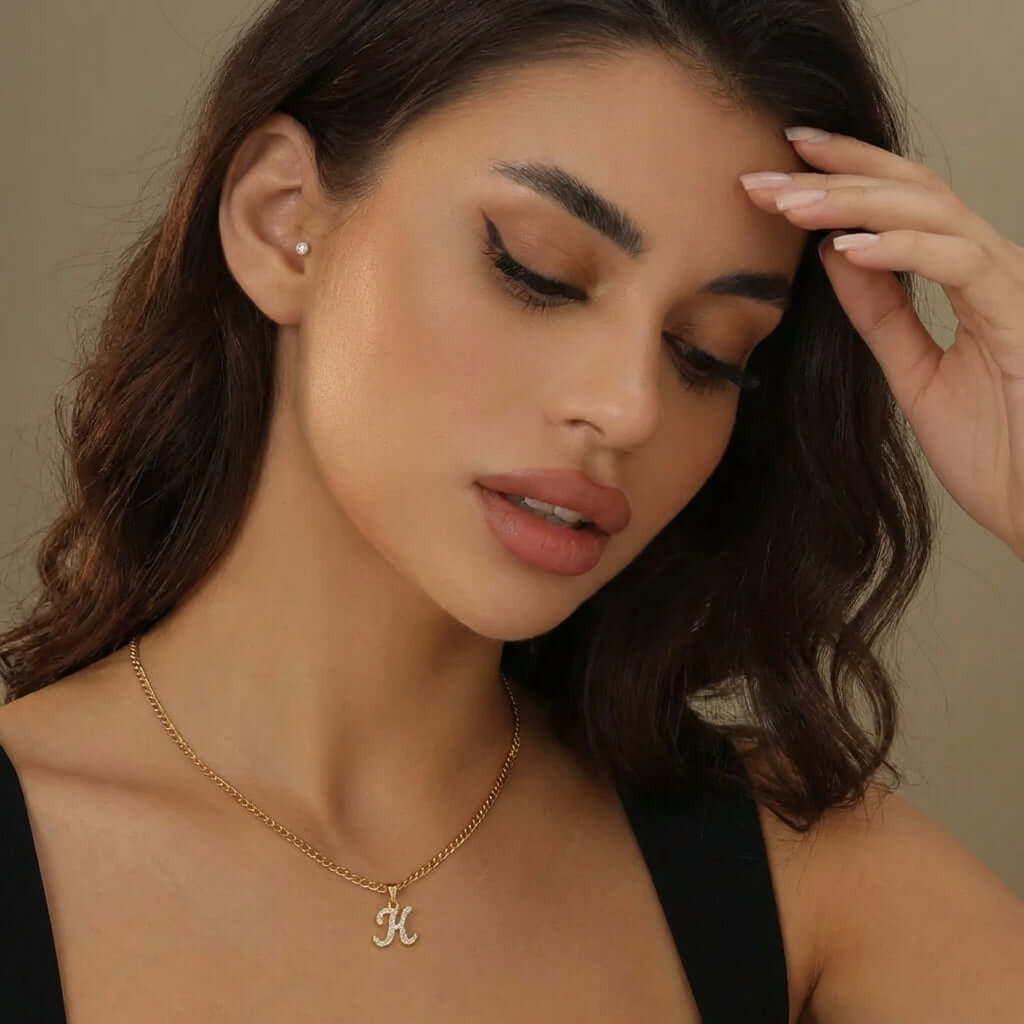 Model wearing AUREATE Iced Script Letter Necklace featuring a sparkling initial 'K' on a delicate chain.