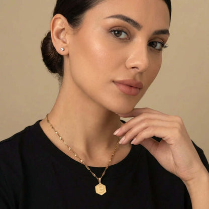 Model wearing AUREATE Hexagon Initial Necklace with a gold hexagon pendant featuring the letter B.