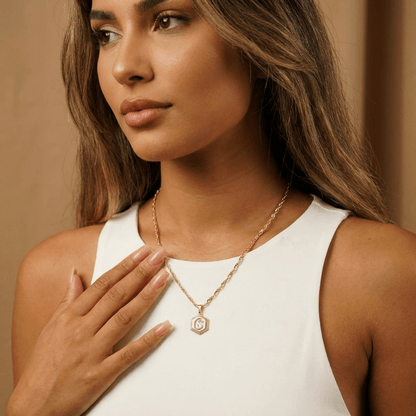 Aureate Hexagon Initial Necklace worn by a woman, showcasing its modern design and unique wave chain.