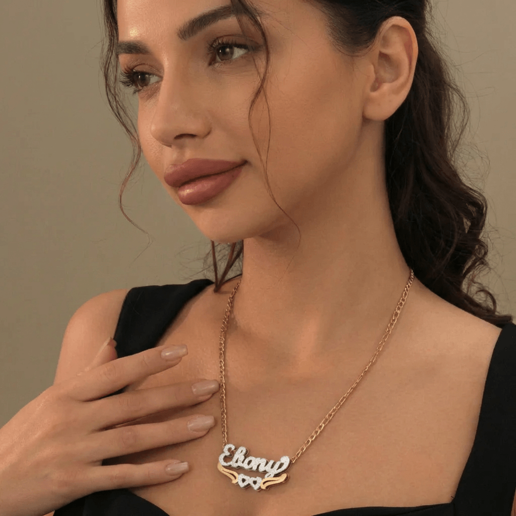 Double Heart Name Necklace with Figaro Chain worn by a model, featuring personalized name detail and AUREATE brand.