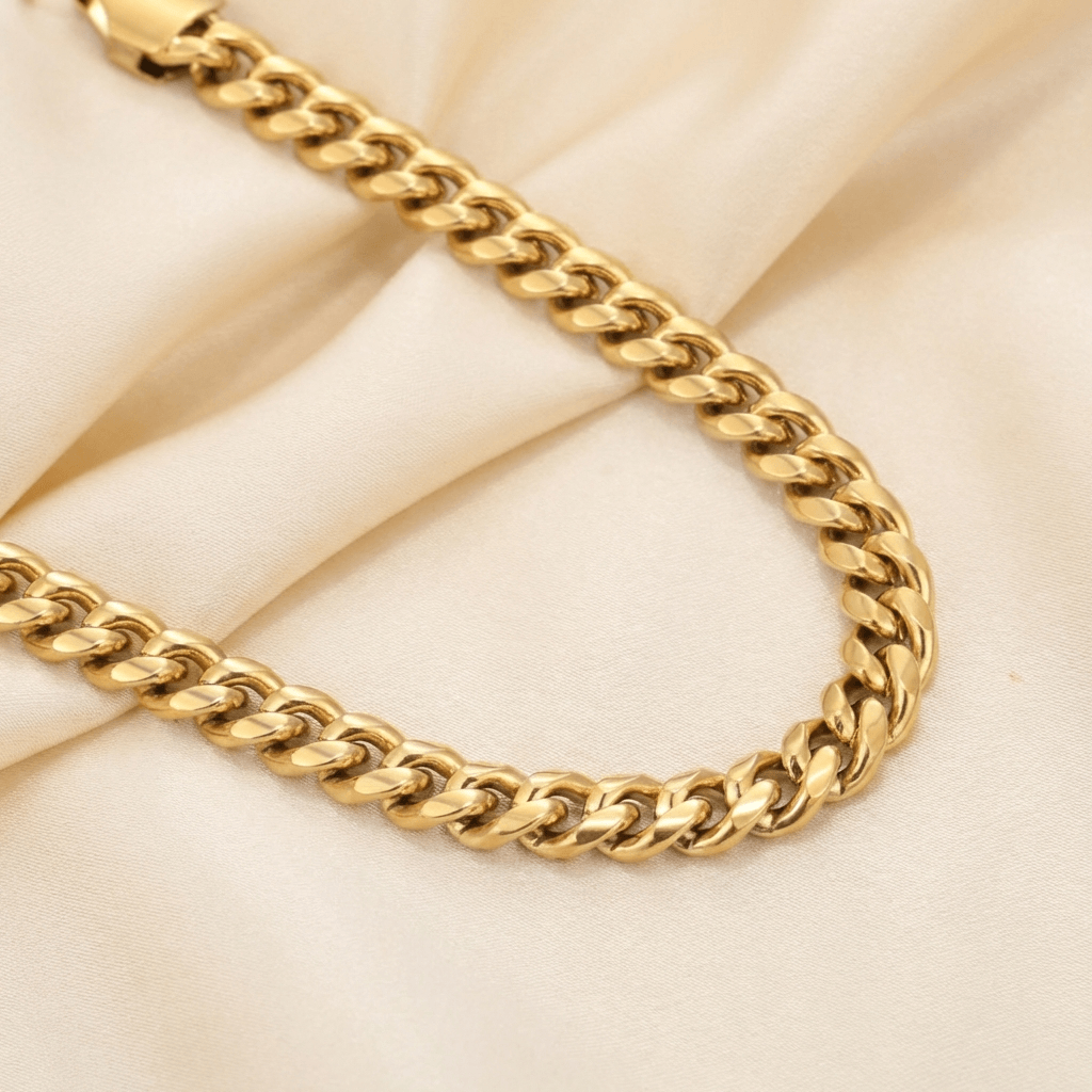 5mm Cuban Link Bracelet by AUREATE, a stylish gold chain on soft fabric background.