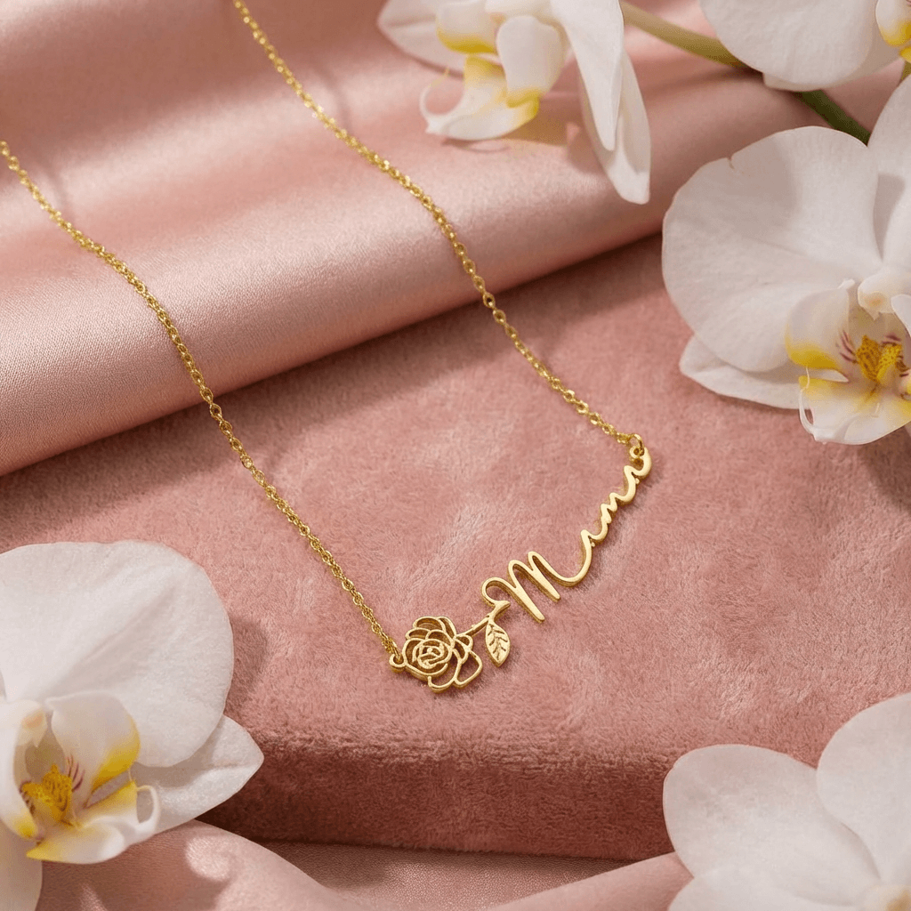Horizontal Birth Flower Name Necklace by AUREATE featuring a gold 'Mama' script with flower detail on a soft background.