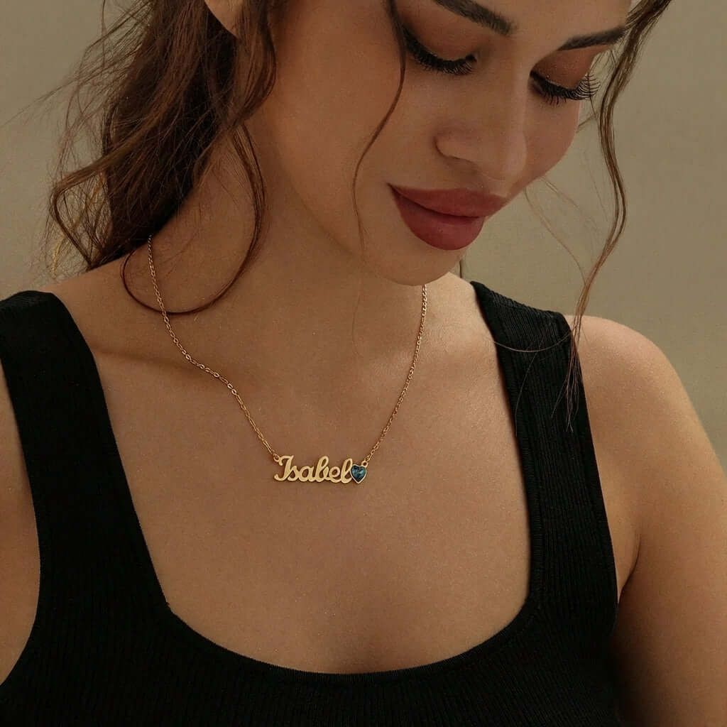 Birthstone Personalised Name Necklace worn by a woman, featuring the name Isabel and a vibrant birthstone detail, AUREATE.
