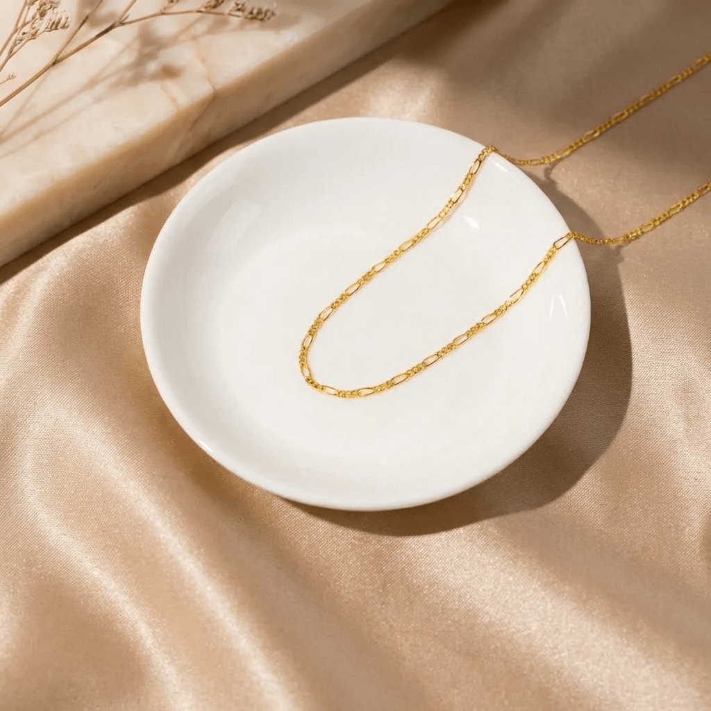 3mm Figaro Chain Necklace by AUREATE on a white dish, featuring elegant alternating links and a modern design.
