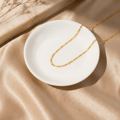 3mm Figaro Chain Necklace by AUREATE on a white dish, featuring elegant alternating links and a modern design.