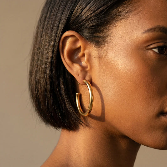 Woman wearing Chunky Gold Hoop Earrings - studio close-up editorial portrait
