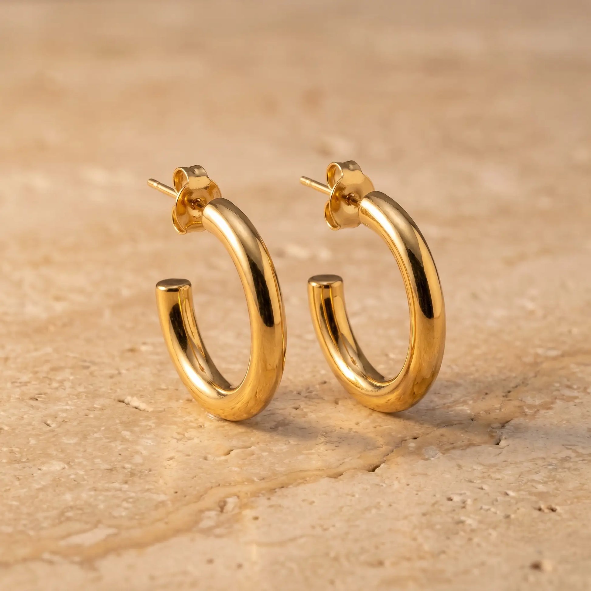 Chunky Gold Hoop Earrings pair - hero packshot on travertine stone