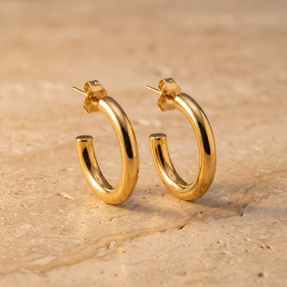 Chunky Gold Hoop Earrings pair - hero packshot on travertine stone