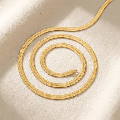AUREATE 5mm Herringbone gold chain coiled product packshot on linen