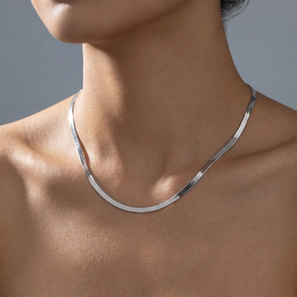 AUREATE 5mm Herringbone silver chain on woman's décolleté studio close-up