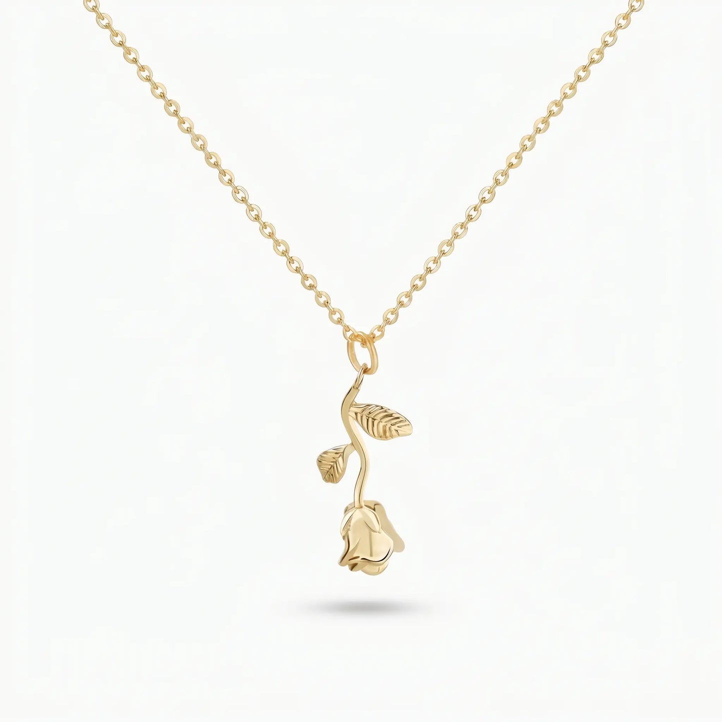 AUREATE Rose Flower Charm Pendant 18K Gold packshot — 3D sculpted long-stem rose with two leaves on a delicate cable chain, isolated on clean white background.