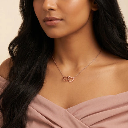 Engraved Double Heart Pendant Rose Gold worn close-up by Latina woman in dusty rose off-shoulder, two interlocked hearts personalized by AUREATE