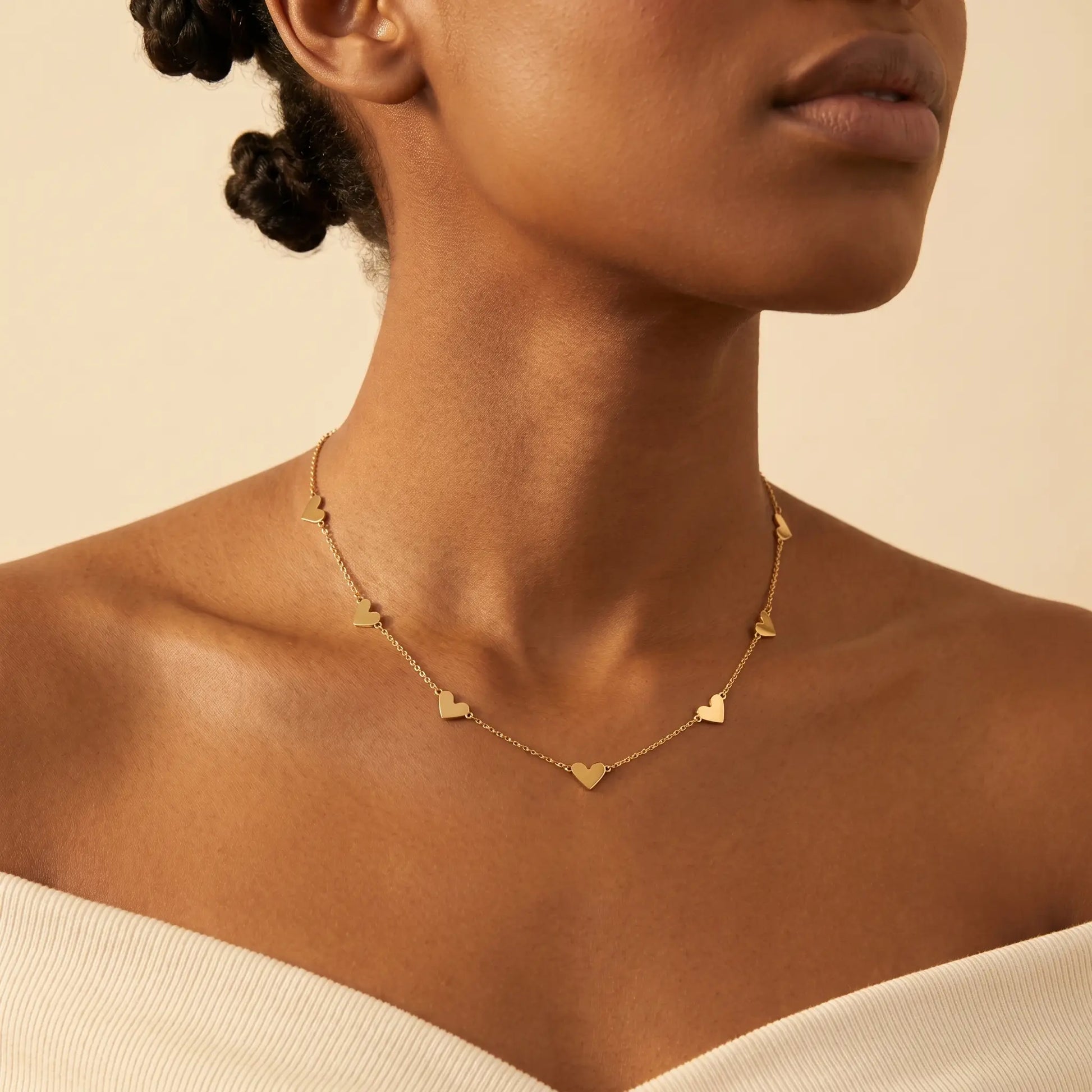 AUREATE Twin Heart Gold Multi-Heart Station Necklace 18K gold worn close-up Black woman editorial luxury