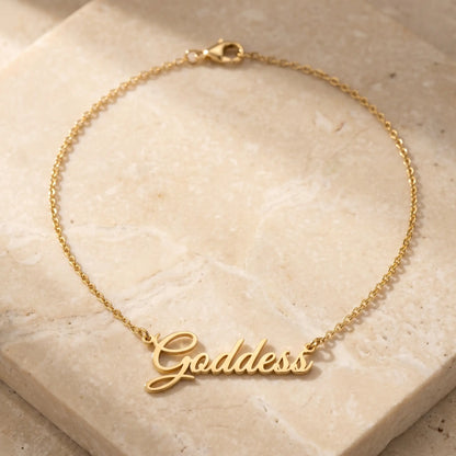 Personalized Script Name Chain 18K gold cursive nameplate packshot on travertine by AUREATE