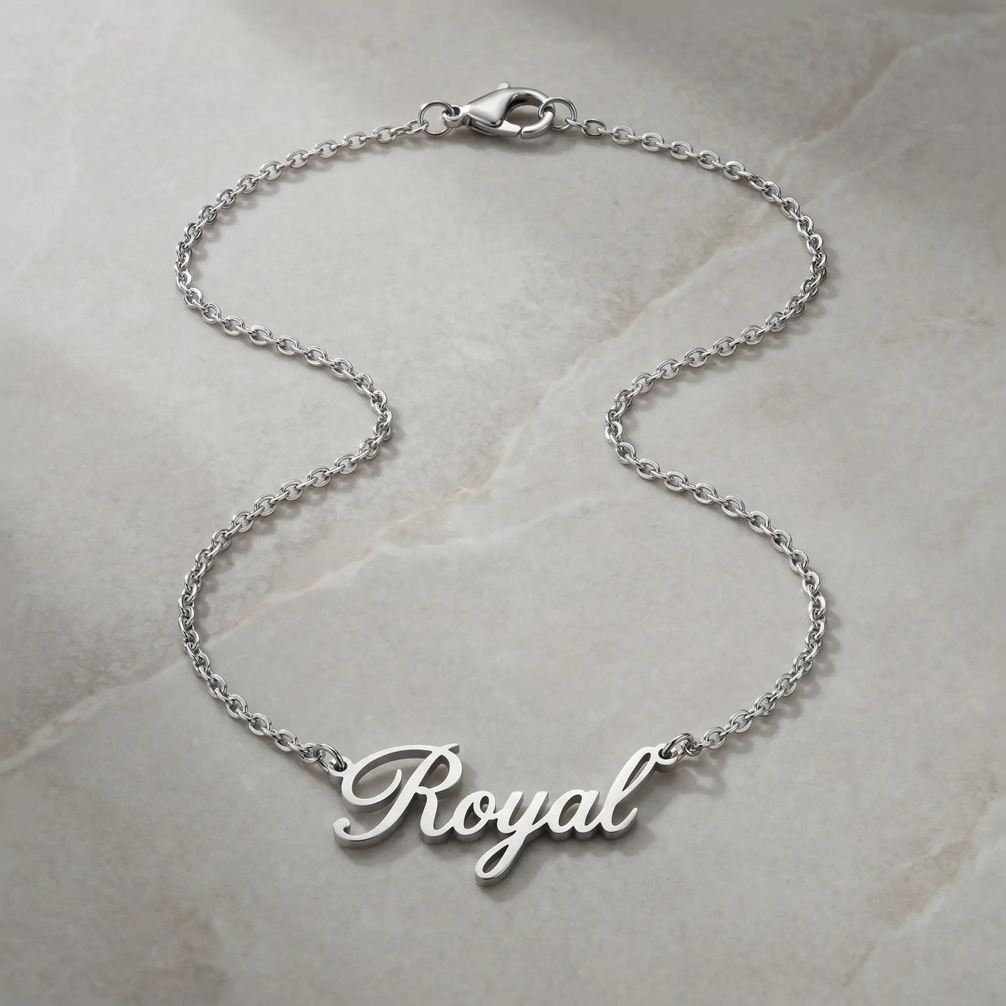 Personalized Script Name Chain silver tone cursive nameplate packshot on cool stone by AUREATE