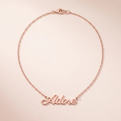 Personalized Script Name Chain rose gold cursive nameplate packshot on blush cream by AUREATE