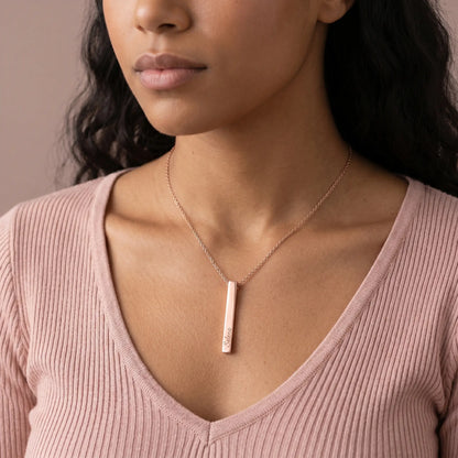 Cuban woman wearing AUREATE Vertical Name Bar Pendant in rose gold engraved with cursive Selena, blush pink ribbed sweater.