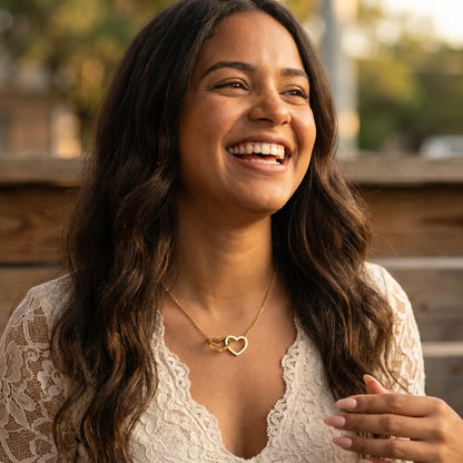 Engraved Double Heart Pendant 18K Gold worn during candid laughter by Cuban woman in cream lace top brunch garden setting by AUREATE
