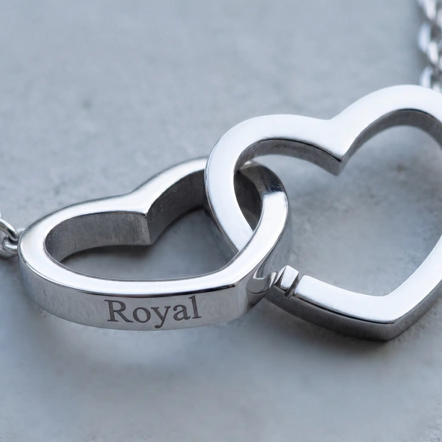Engraved Double Heart Pendant Silver macro detail by AUREATE, two interlocked open-outline hearts with Royal engraving cool Nordic light premium craftsmanship