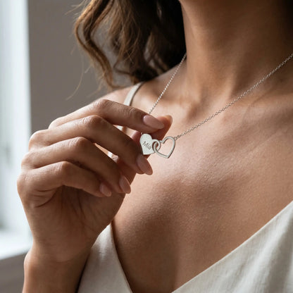 Engraved Double Heart Pendant Silver lifestyle hand close-up Filipina woman fingertips touching Mia personalized engraving intimate cool light moment by AUREATE