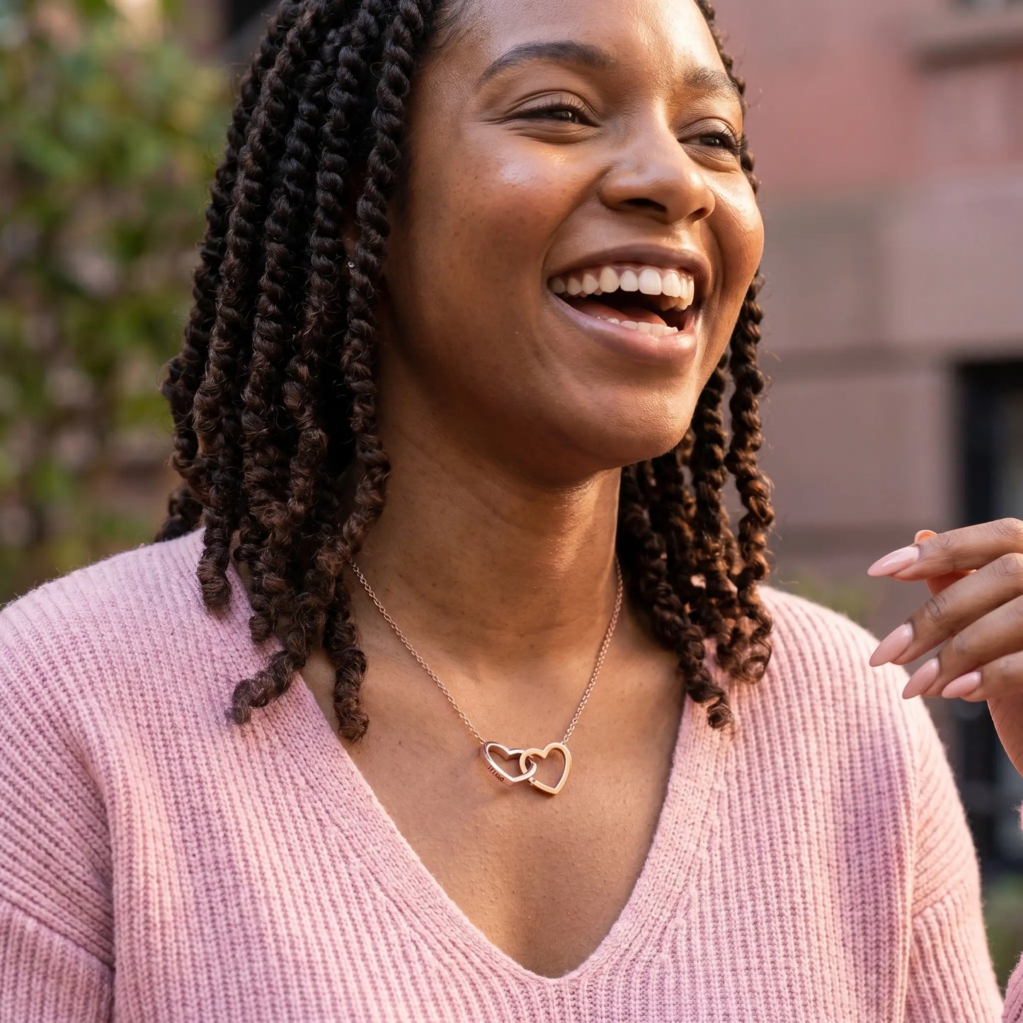 Engraved Double Heart Pendant Rose Gold candid laughter African American woman in soft pink ribbed knit Brooklyn brownstone garden by AUREATE