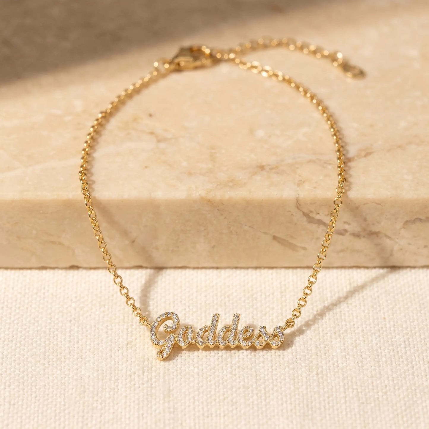 Crystal Name Wrist Chain in 18K Gold packshot - delicate rolo chain with iced cursive nameplate by AUREATE