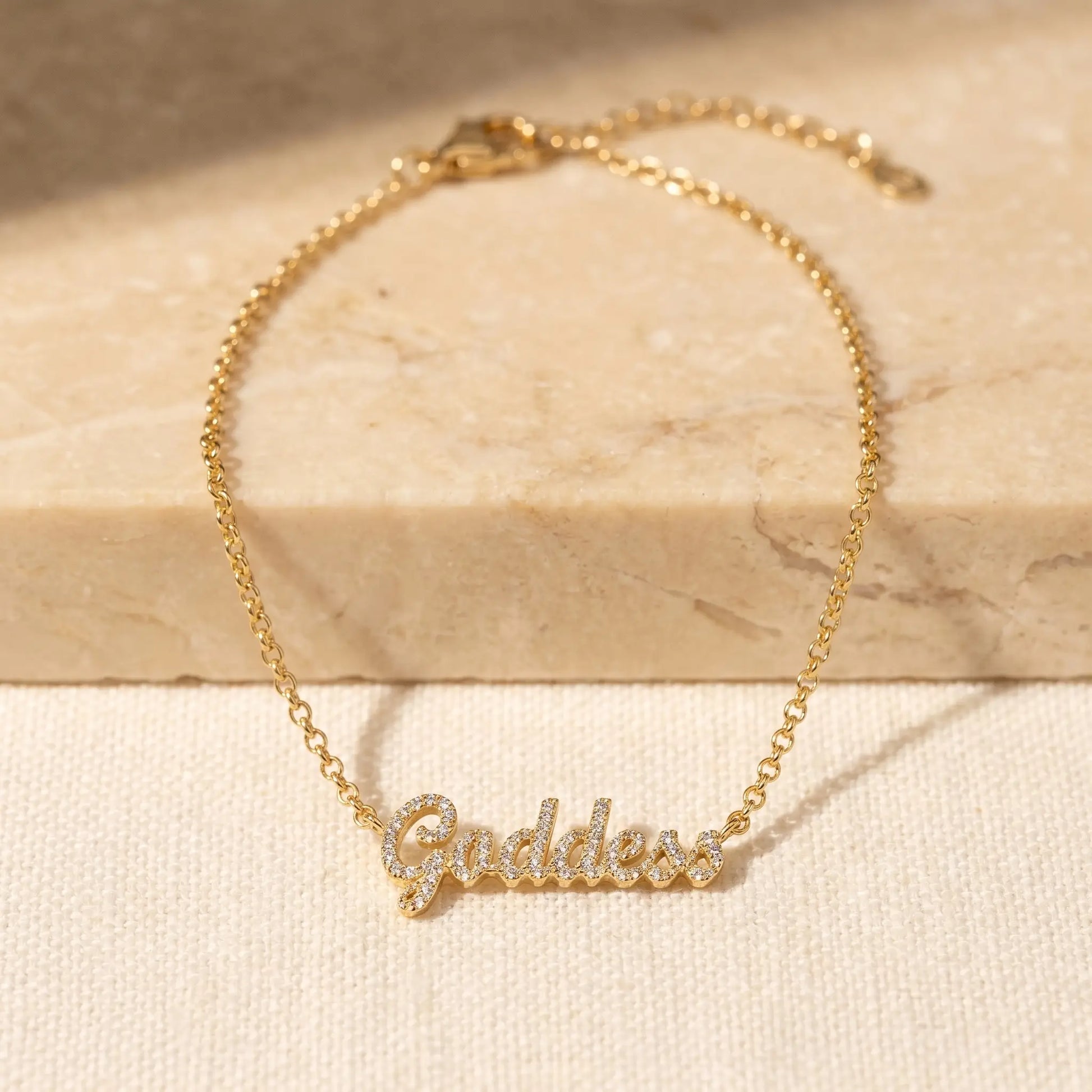 Crystal Name Wrist Chain in 18K Gold packshot - delicate rolo chain with iced cursive nameplate by AUREATE