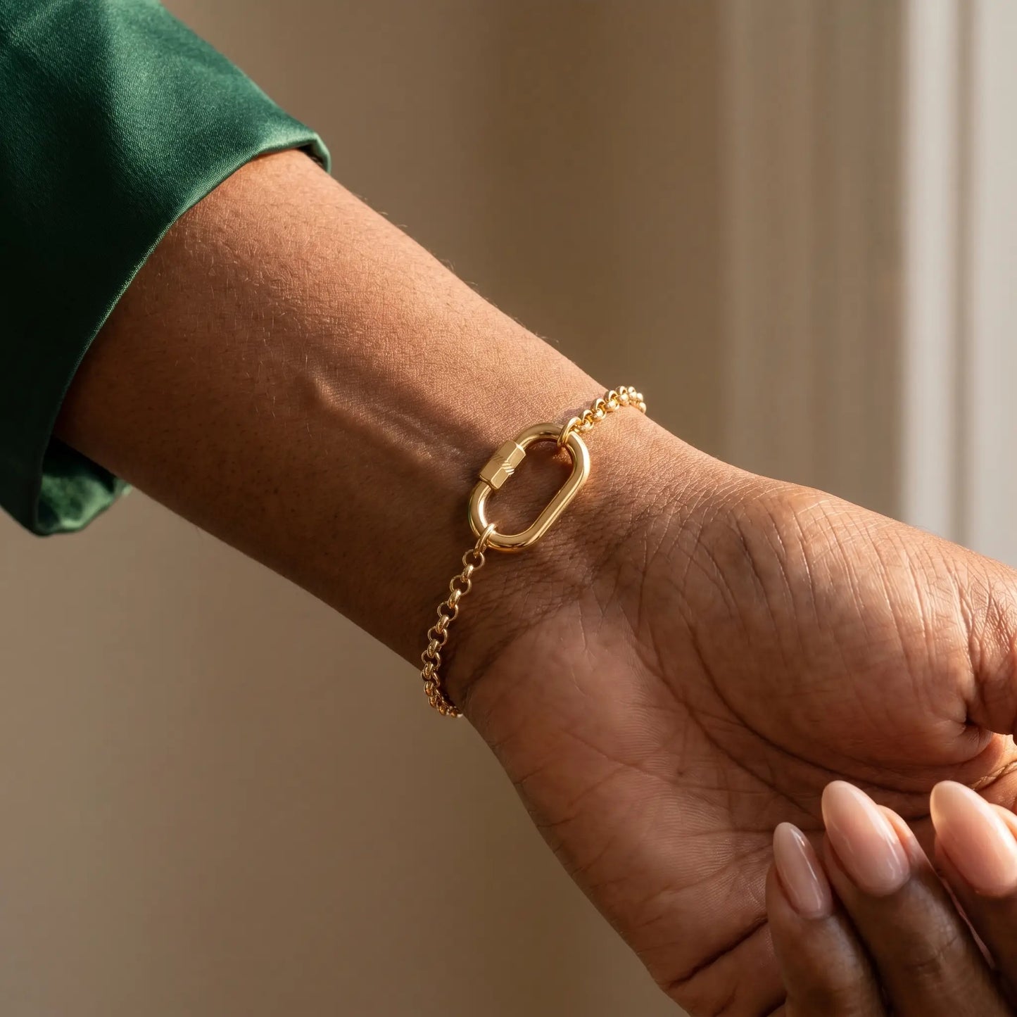 Oval Buckle Charm Bracelet gold rolo chain on wrist close-up
