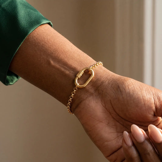 Oval Buckle Charm Bracelet gold rolo chain on wrist close-up