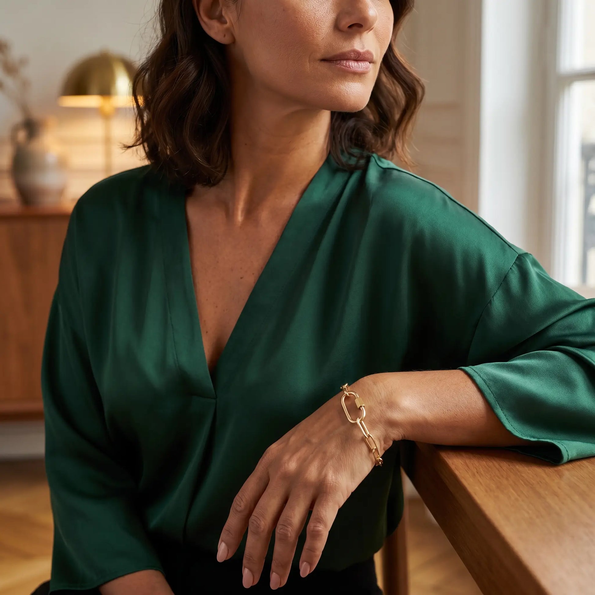 Gold paperclip bracelet on mature woman's wrist - editorial elegant Vogue style