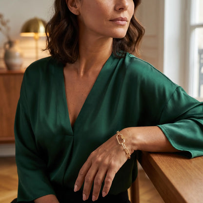 Gold paperclip bracelet on mature woman's wrist - editorial elegant Vogue style