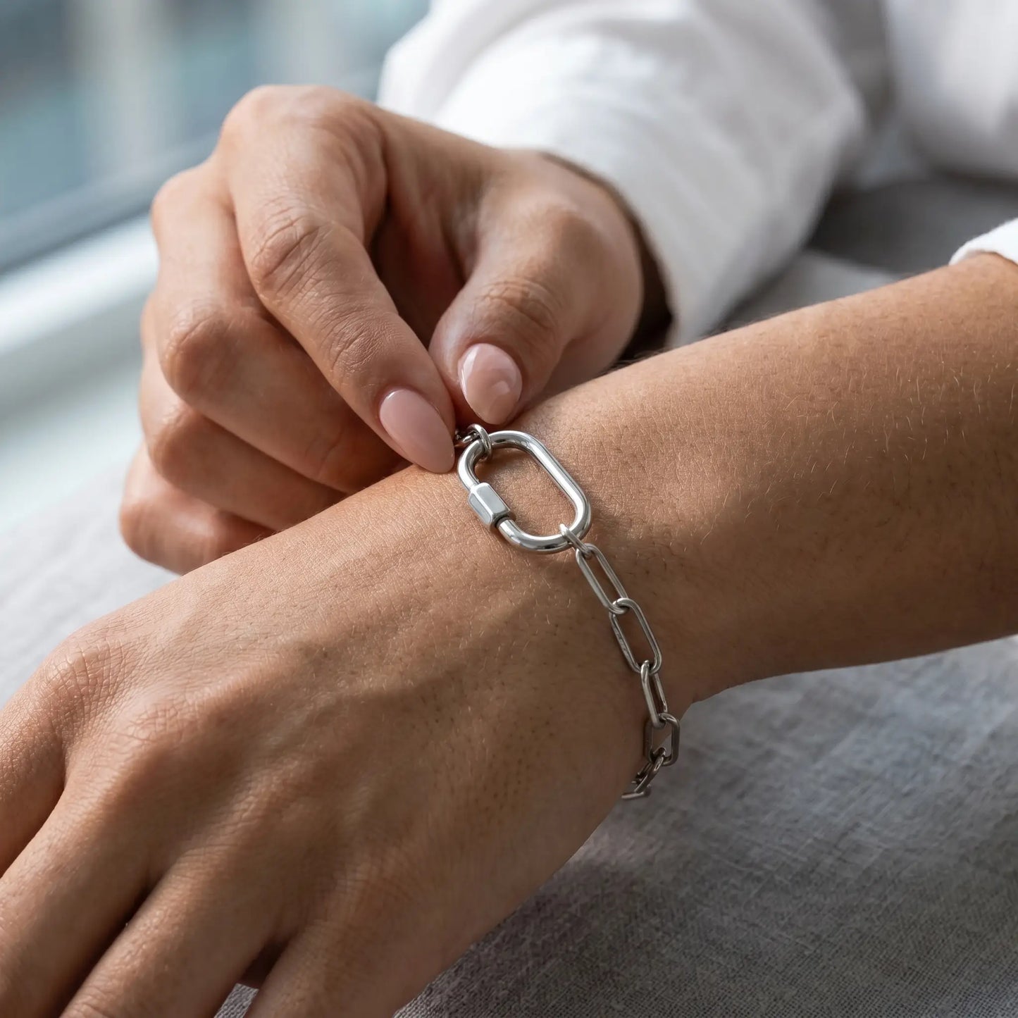 Silver paperclip bracelet intimate hand-to-jewelry close-up