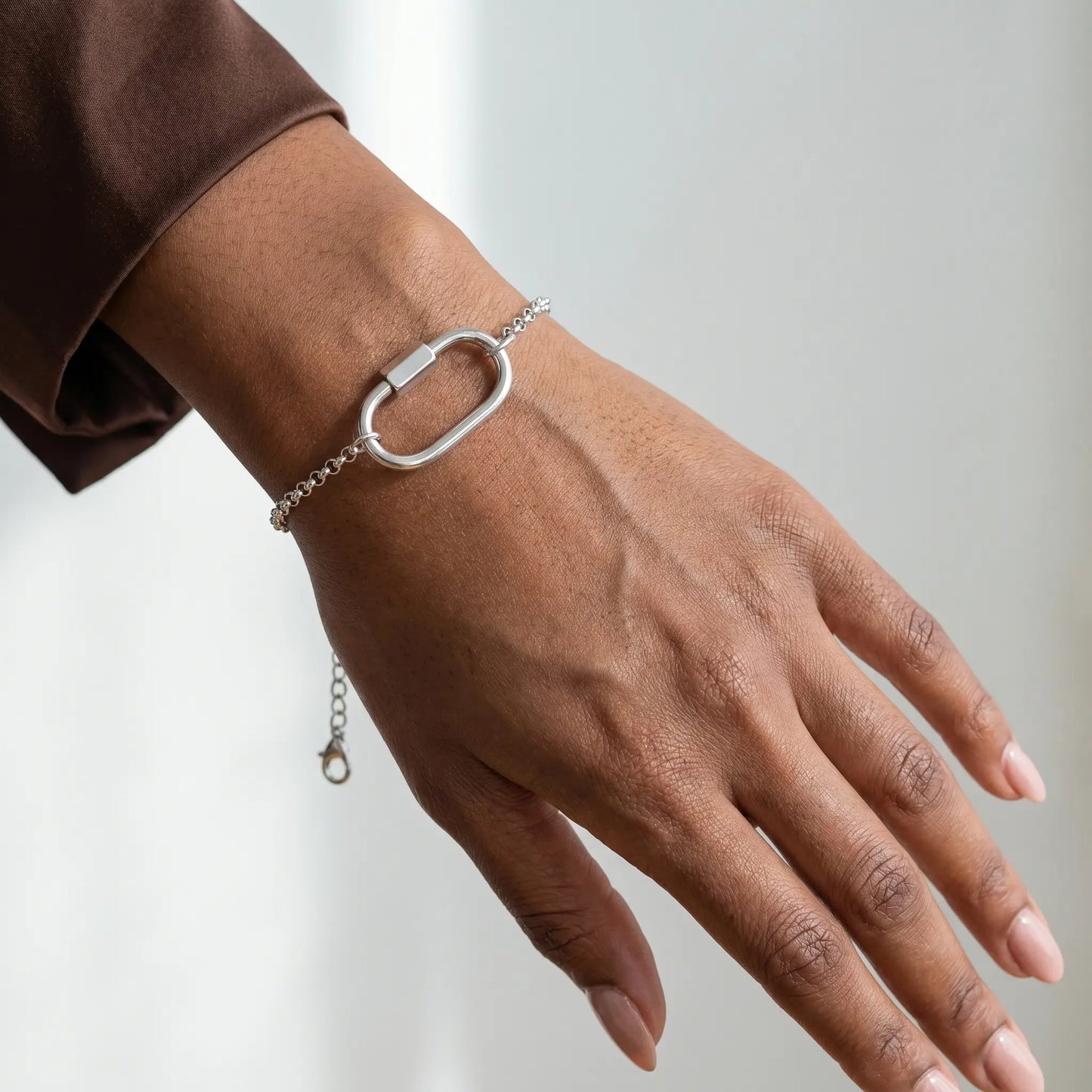 Oval Buckle Charm Bracelet silver rolo chain on wrist close-up