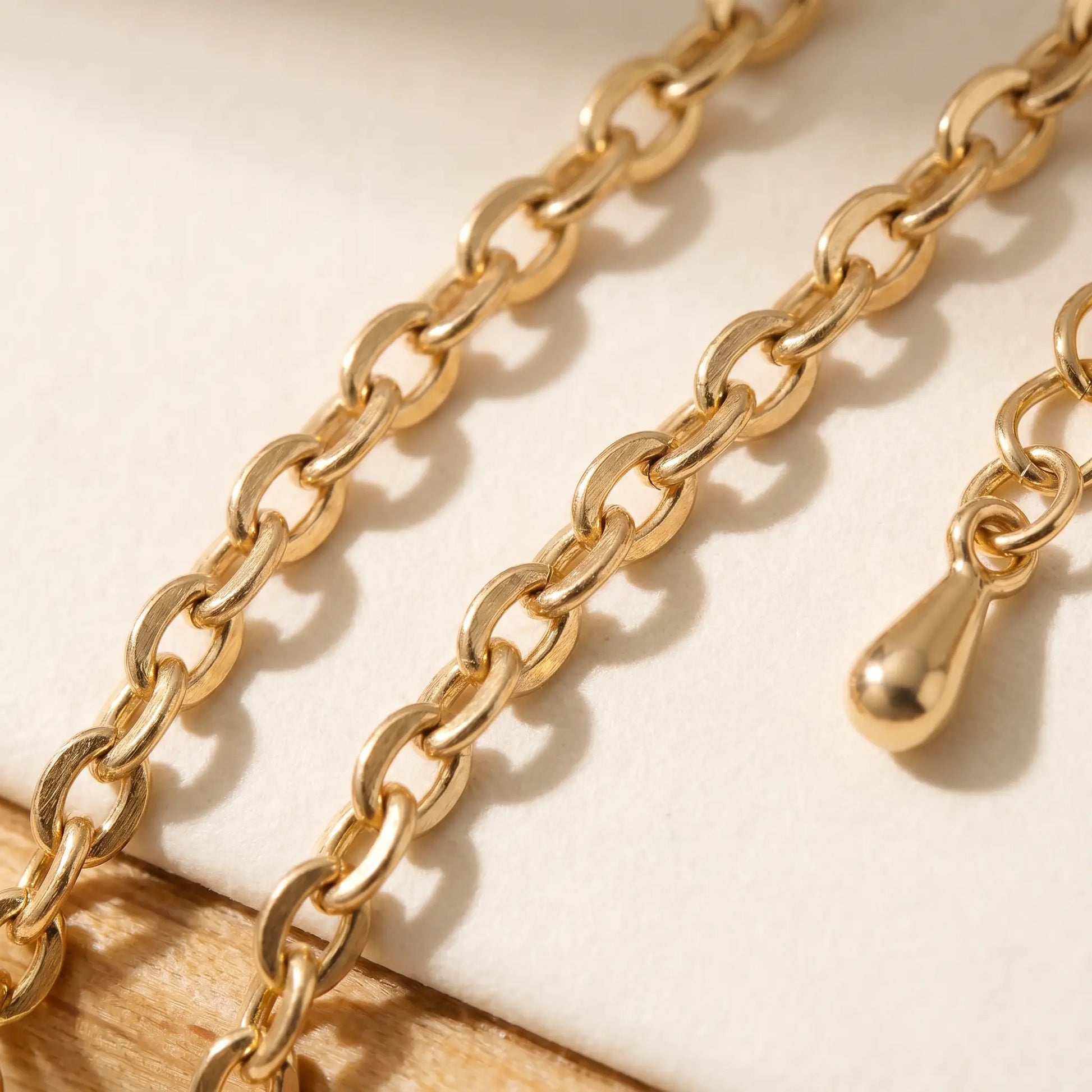 Gold fine cable chain macro detail teardrop weight