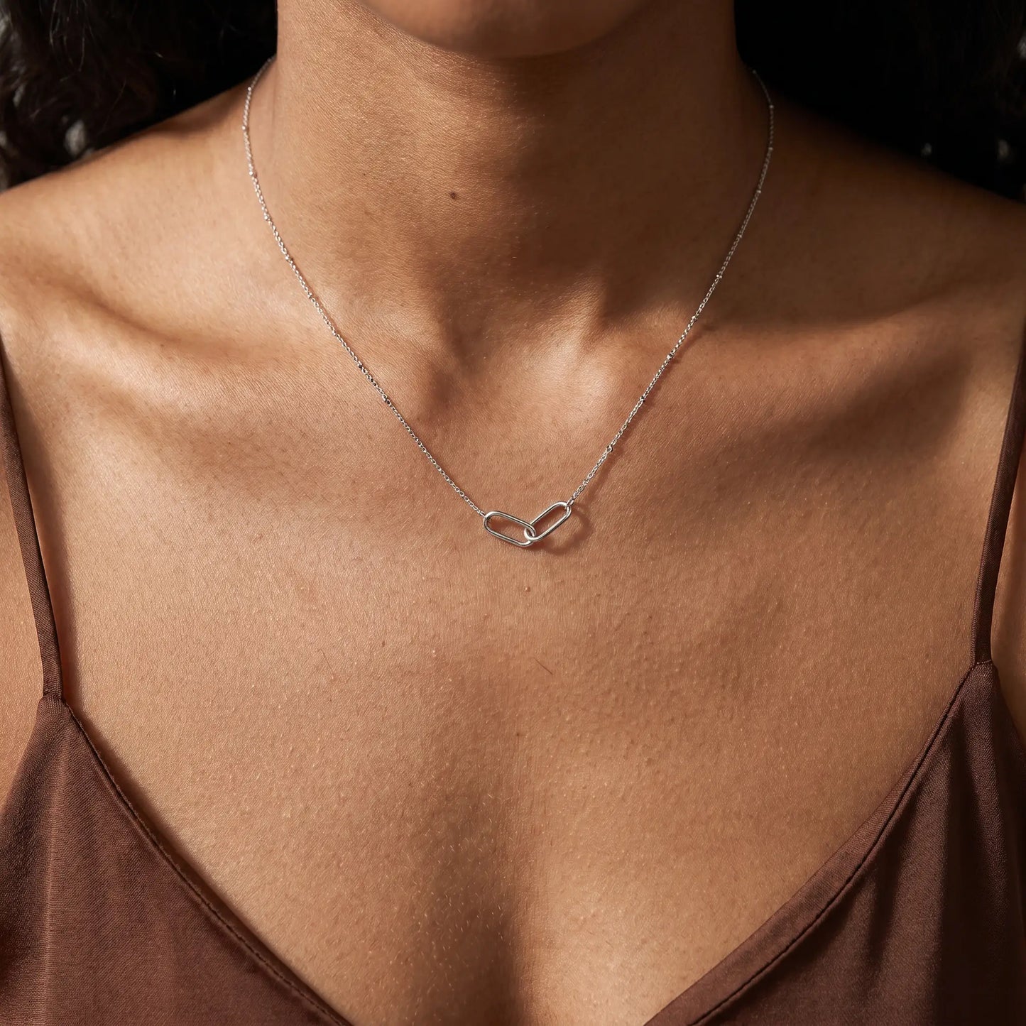 Linked Loop Necklace silver tone worn close-up decollete African American