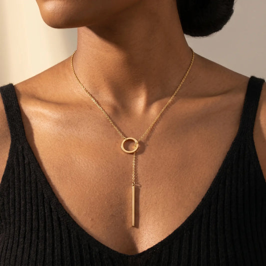 Gold lariat Y necklace worn on decollete close up