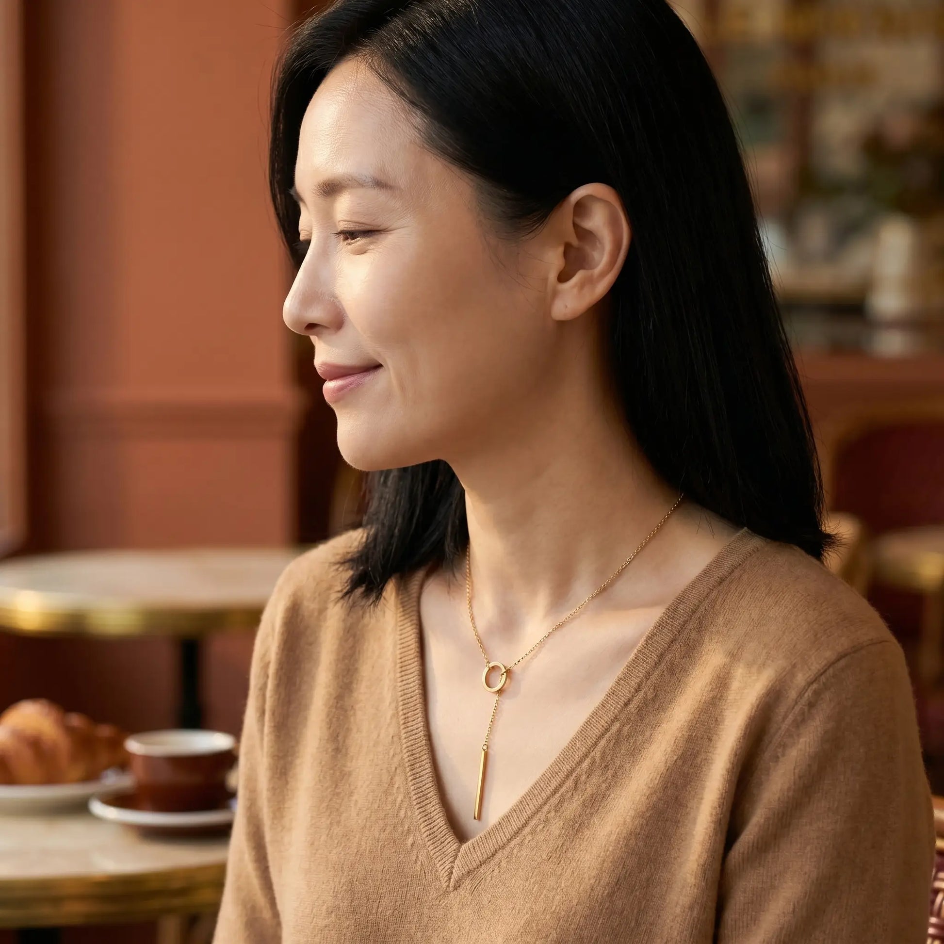 Gold lariat necklace subtle smile profile Paris cafe