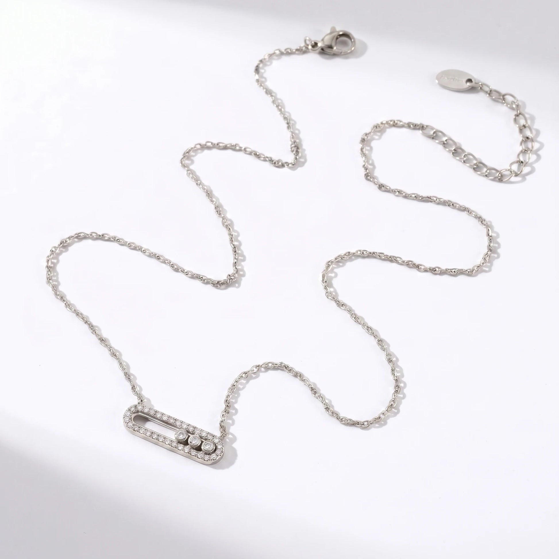 Silver paperclip pendant necklace flat lay packshot HORIZONTAL oval pendant 3 sliding CZ stones